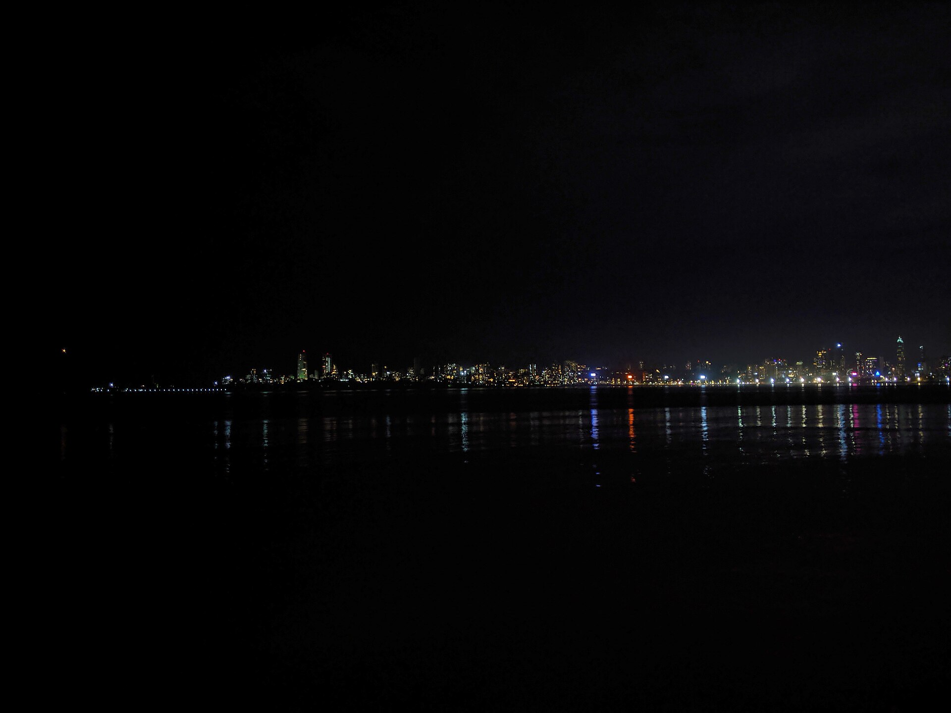Mumbai's Marine Drive skyline at night, city lights reflecting on the water